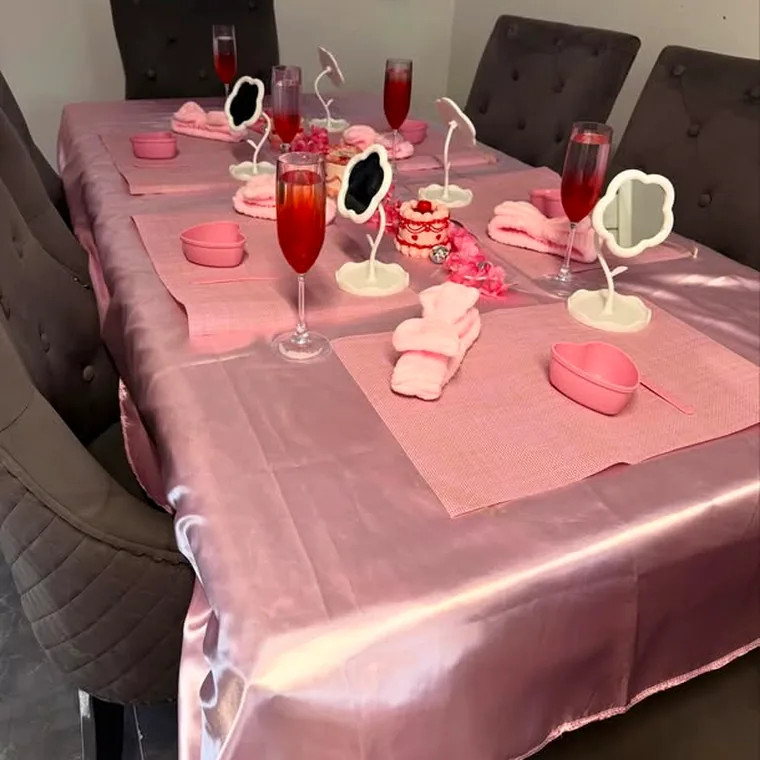 A dining table dressed for a pamper party with mocktails, mirrors and folded towels